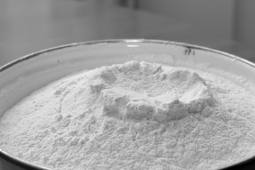 White enamel bowl with wheat flour close-up