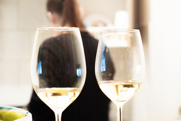 Two glasses of white wine at the bar on the background of the girl.