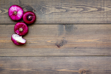 Red onion for salads on dark wooden background top view copy space