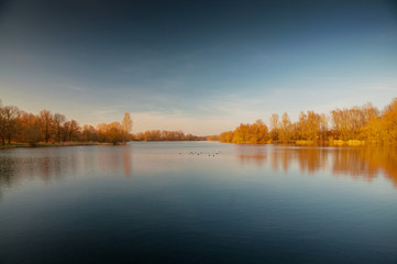 Panorama view of a lake with blue sky and golden sunset light. Südsee in Braunschweig, Germany
