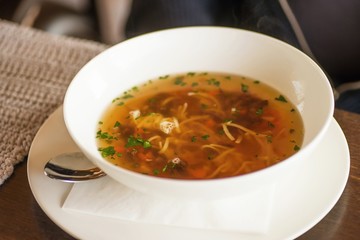 Strong beef soup in white bowl.