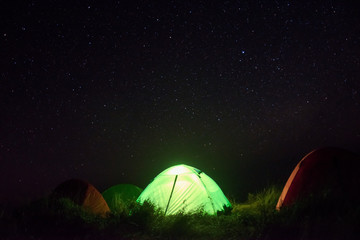 green tent for camping among many star in night time