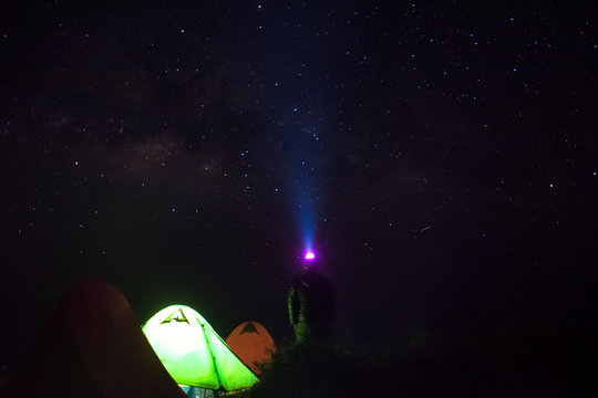 man stand up near green tent camping and  looking milky way star in night time
