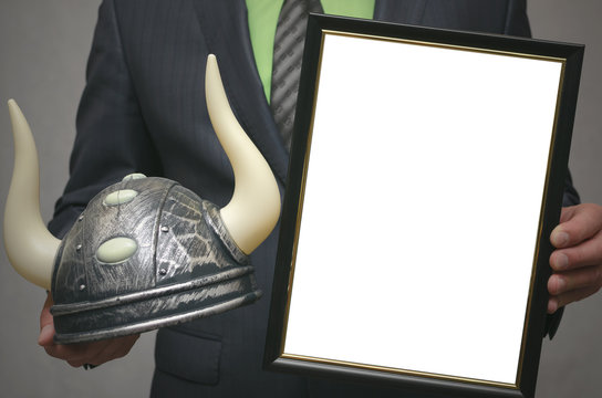 Best bull stock broker. Diploma template of best player for raising stock prices on the exchange. Businessman holding viking helmet and blank photo frame in hands.