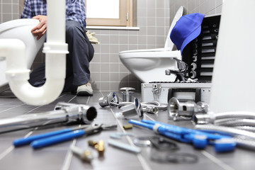 plumber at work in a bathroom, plumbing repair service, assemble and install concept