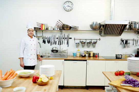 Professional chef of restaurant standing by sink in the kitchen in working environment