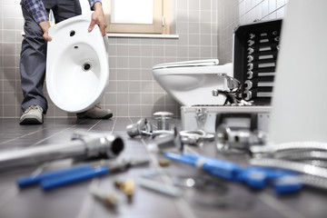 plumber at work in a bathroom, plumbing repair service, assemble and install concept