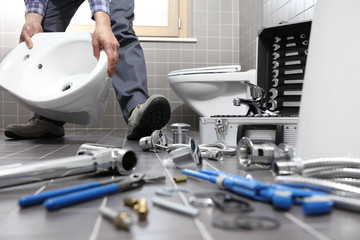 plumber at work in a bathroom, plumbing repair service, assemble and install concept