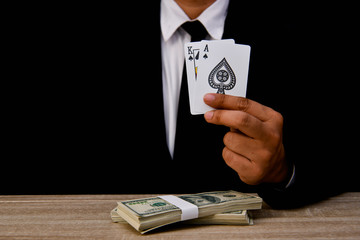 Gambling Concepts. Businessmen are gambling in the casino. Betting is a gamble for investors. Businessmen are playing card games on a black background.