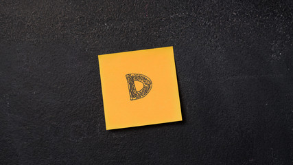 Sticky note with letter "D" on the blackboard
