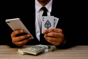 Gambling Concepts. Businessmen are gambling in the casino. Betting is a gamble for investors. Businessmen are playing card games on a black background.