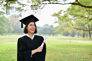 Graduation Concept. Graduated students on graduation day. Asian students are smiling happily on the graduation day. Students wear graduation gowns in the garden