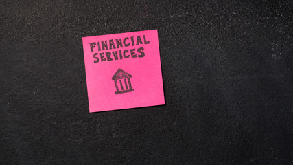 Sticky note with Financial Services words on the blackboard