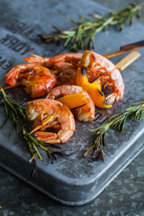 Fototapeta na wymiar Grilled shrimps. Shrimps skewers, fresh herbs rosemary. copyspace