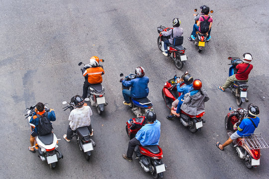 Fototapeta People are on motorbikes in huge Asian city