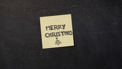 Sticky Merry Christmas note on the blackboard