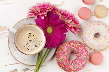 Obraz na płótnie Canvas Coffee cup, donuts and gerbera flowers