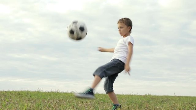 One happy little boy playing football. Concept of sport.