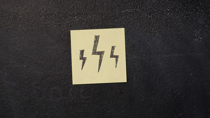 Sticky note with lightnings drawing on the blackboard