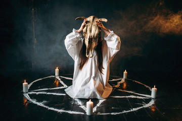Woman holds skull of the animal in hand, occultism