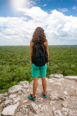 Touristin steht auf der Spitze der Nohoch Mul Pyramide in Coba, Mexiko, und schaut über den tropischen Regenwald