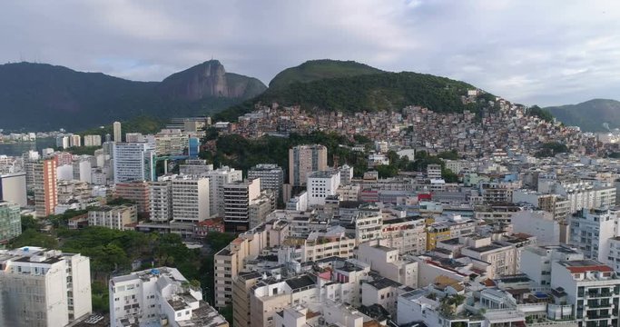 Aerial view above city buildings and shanty town (favela) with Corcovado hill in the distance. Rio de Janeiro, Brazil