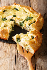 Snack crispy pie with artichokes, cheese and spinach close-up. vertical