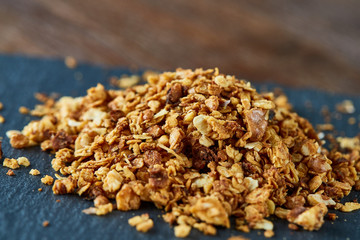 Healthy mix of granola and oatmeal on dark background, top view, close-up, selective focus