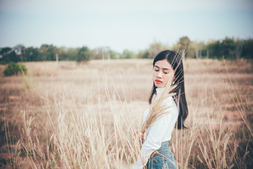 Happy asian woman with beautiful stand on fence at the field,lifestyle of single girl