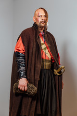 Severe warrior Russian Cossack, face in scars, bald. Bled blood. Saber in sheath.