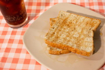 Honey bread with cola on tablecloth background. Closeup.