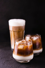 Iced coffee in glasses with milk. Black background