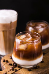 Iced coffee in glasses with milk. Black background