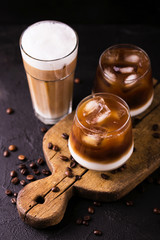 Iced coffee in glasses with milk. Black background