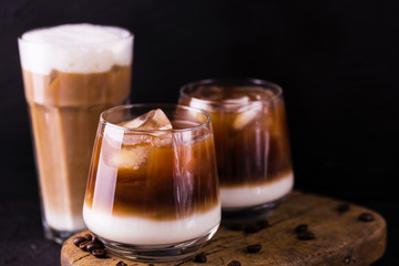 Iced coffee in glasses with milk. Black background