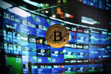 coin bitcoin against the background of the monitor with exchange rate quotes
