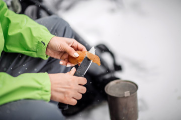 Close-up hand hunter woman with knife in the forest.