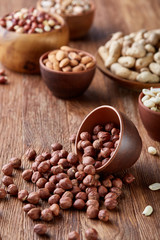 A composition from different varieties of nuts in a wooden bowls on rustic background, close-up, shallow depth of field