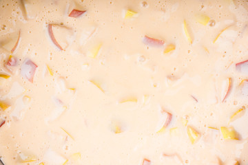 Raw dough with apples for apple cake in a baking dish