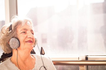 Senior woman with headphones listening to music