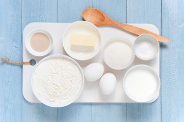 Ingredients for baking end spoon on the textured blue wooden table