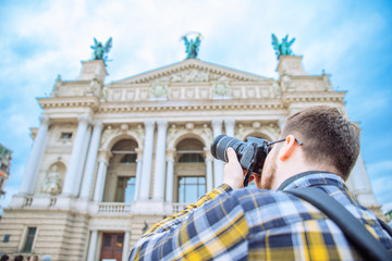 tourist man taking picture of old european architecture. copy space. travel concept