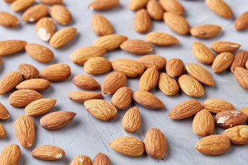 A pile of shelled almond nuts isolated against white background, close-up, top view, selective focus.
