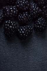 Blackberry Background. Closeup of fresh blackberries  on black textured  background with copy space.