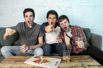 young group of happy and excited men watching a football game on the couch