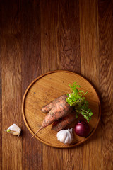 Artistically served vegetable salad with carrot, cucumber, letucce over wooden background, selective focus