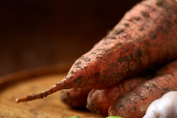 Colorful various of organic farm vegetables with fresh carrots on wooden rustic background, top view, selective focus
