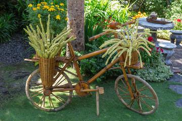 Fototapeta na wymiar Gartengestaltung. Holz Fahrrad als Blumenständer im Garten.
