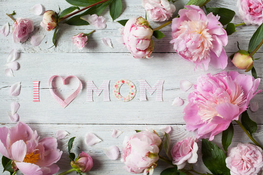 Background to Mother's Day with congratulations and pink peonies and roses