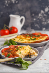 Delicious bright egg omelet with cheese and vegetables. Breakfast food concept, dark background